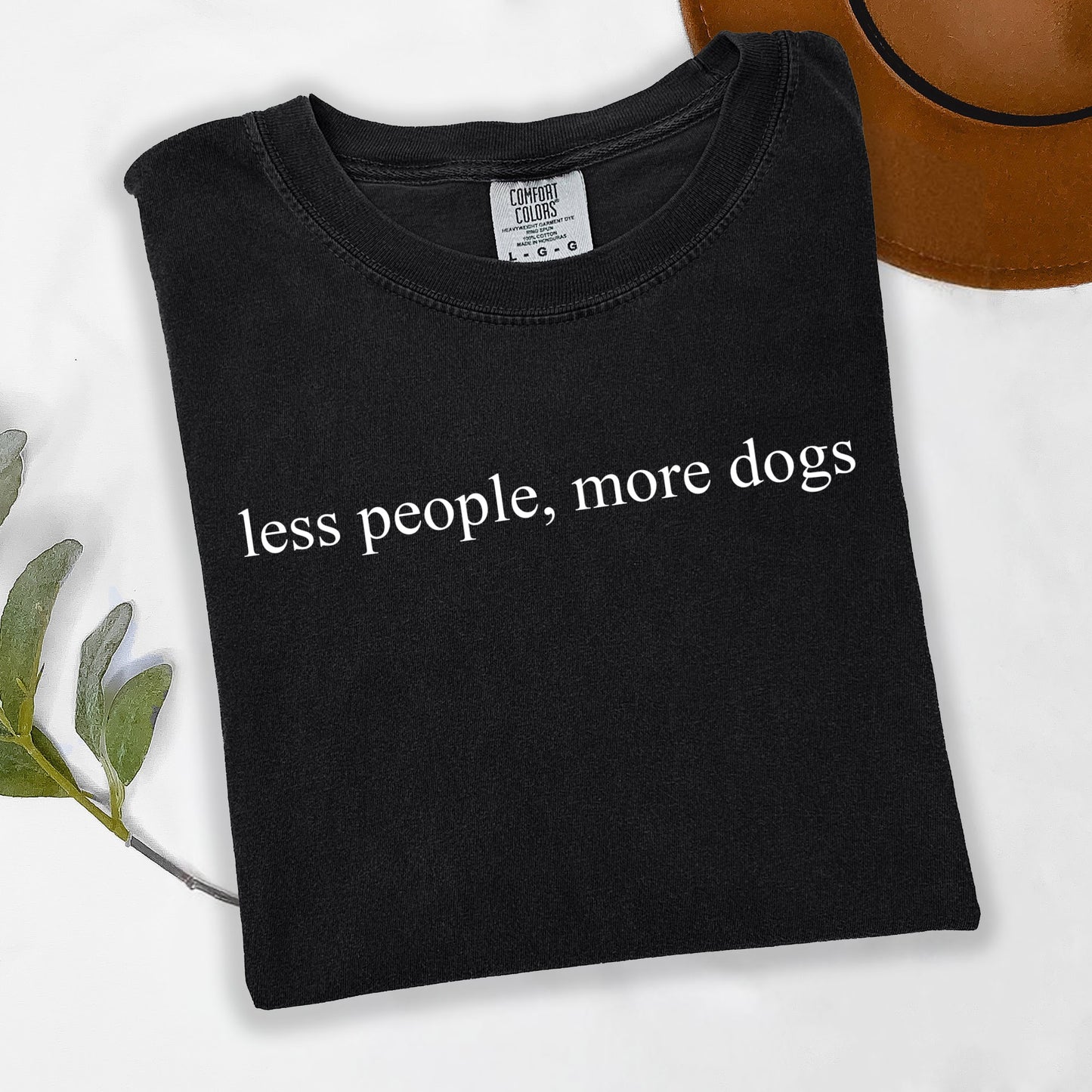 Black t-shirt with 'less people, more dogs' text on a white background