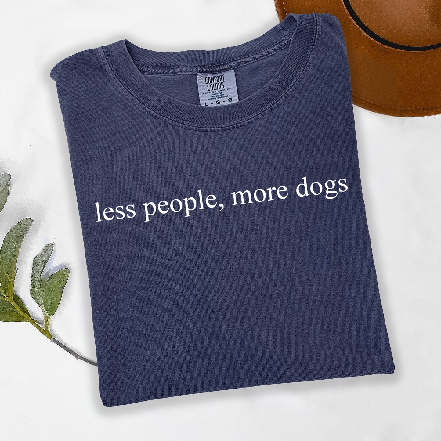 Navy blue t-shirt with 'less people, more dogs' text on a light background