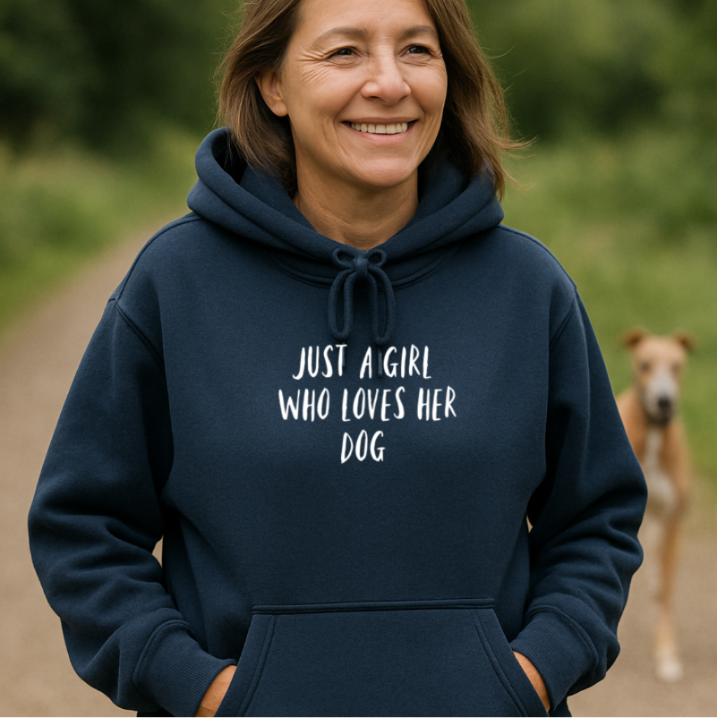 Woman wearing a navy hoodie with 'Just a girl who loves her dog' text, standing outdoors with a dog in the background.