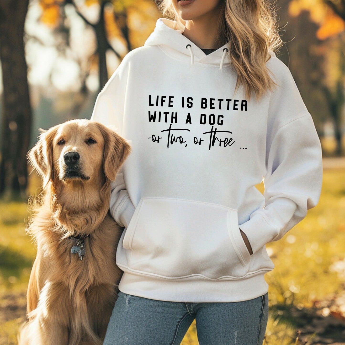 A person wearing a white hoodie with the text 'LIFE IS BETTER WITH A DOG OR TWO, OR THREE.