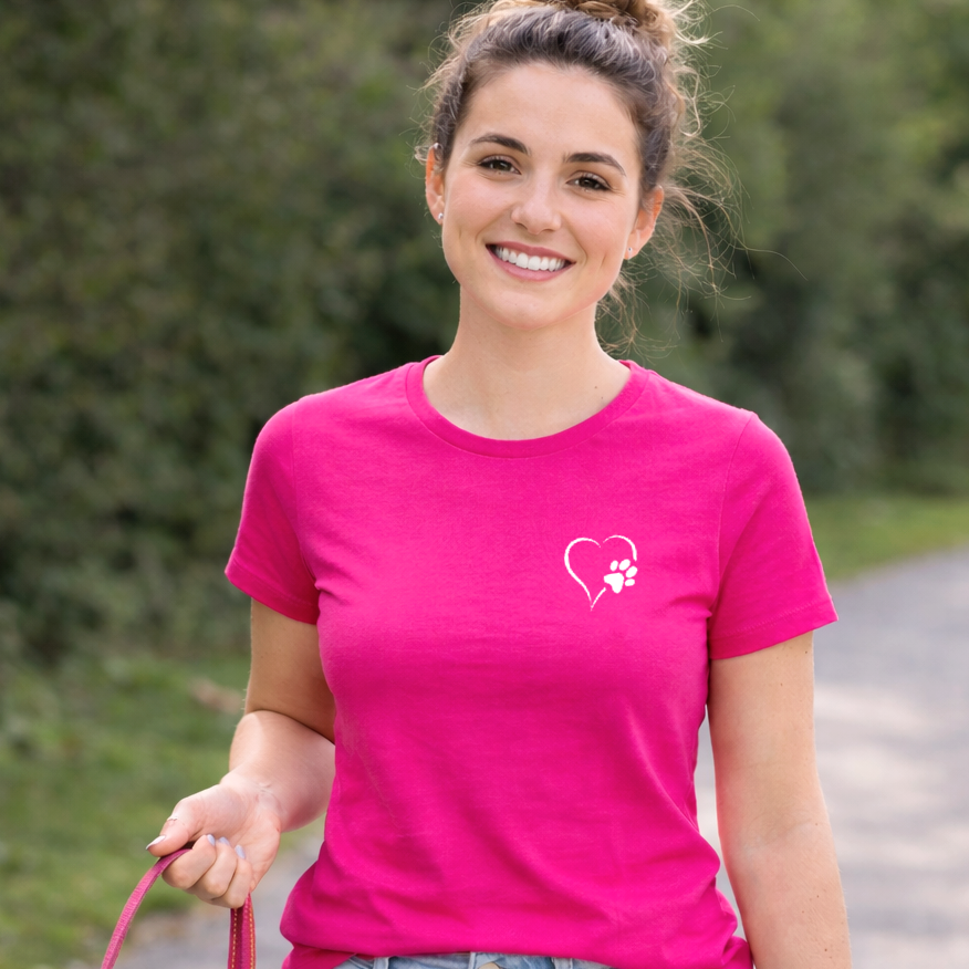 Woman wearing a pink t-shirt with a heart and paw print design, standing outdoors.