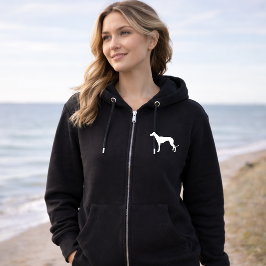 Woman wearing a black hoodie with a white dog logo on a beach