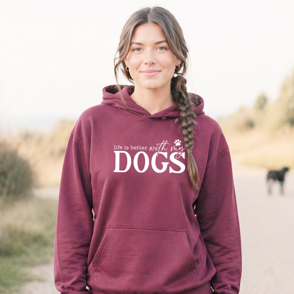 Woman wearing a maroon hoodie with 'life is better with my DOGS' text, standing outdoors.