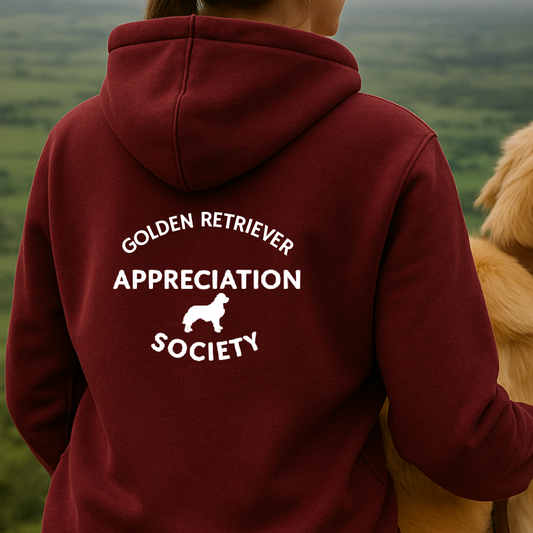 Person wearing a maroon hoodie with 'Golden Retriever Appreciation Society' text and a dog on a scenic background
