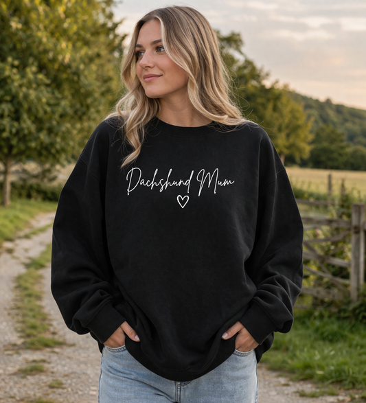 Woman wearing a black sweatshirt with 'Cockapoo Mum' text, standing outdoors.
