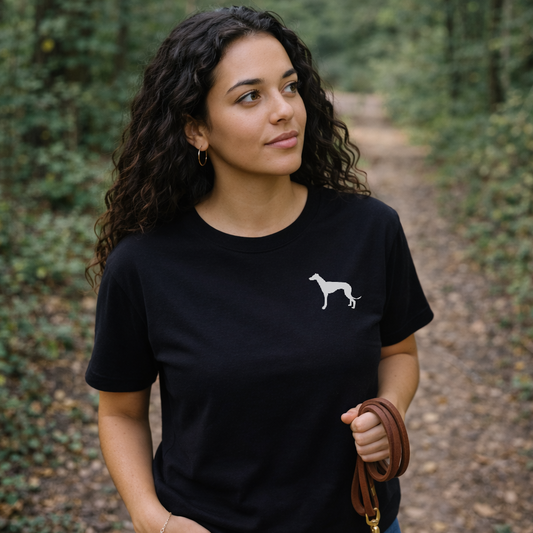 Woman wearing a black t-shirt with a white dog silhouette in a forest setting