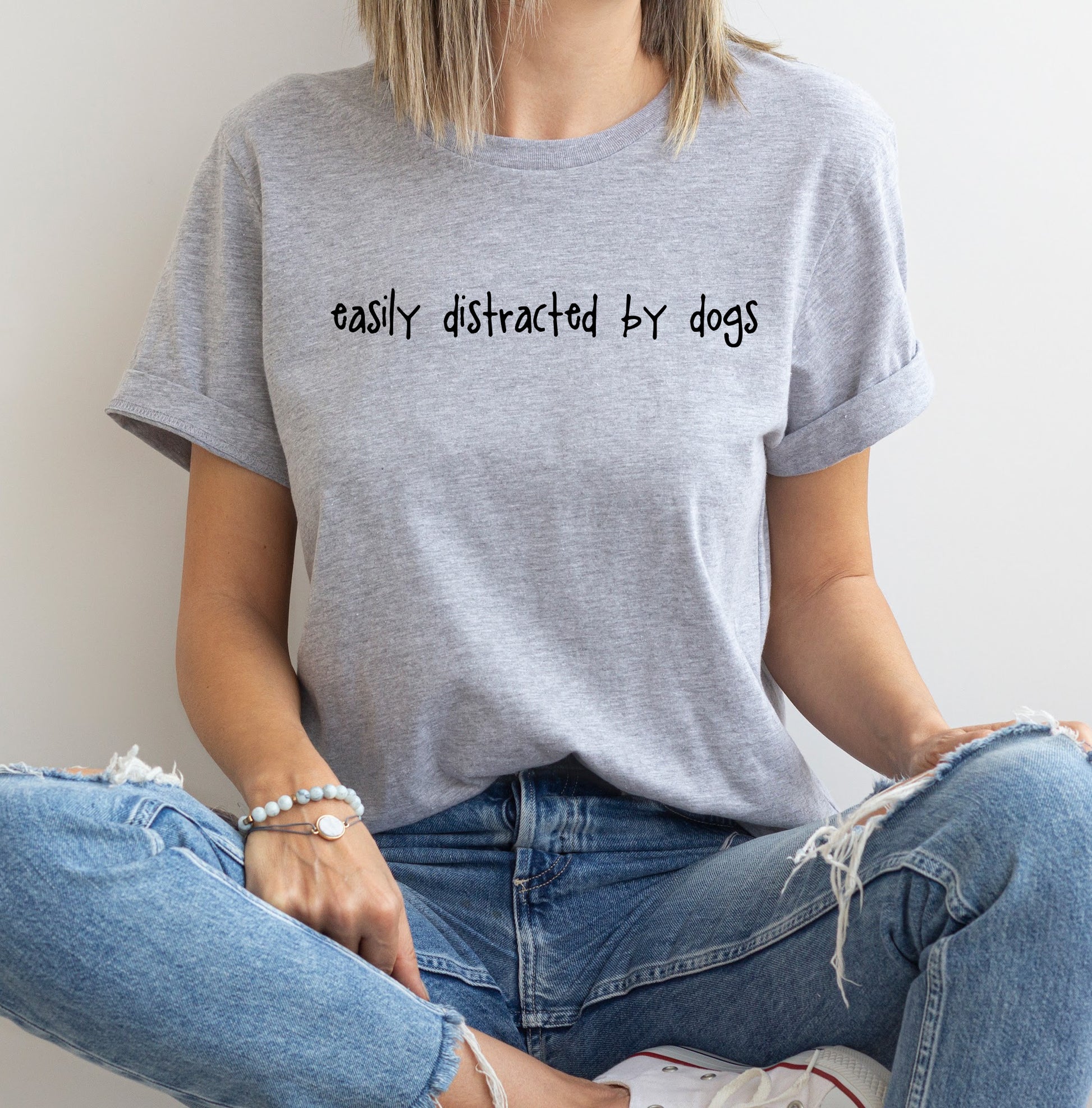 A grey organic cotton t-shirt with the text 'easily distracted by dogs' printed in white.